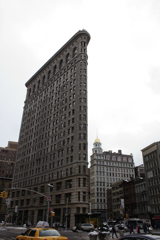 large city buildings with many windows, cars and bikes on the street