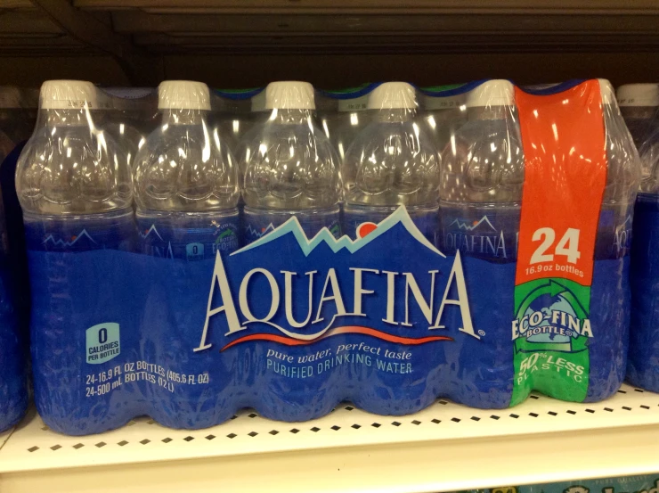 a set of water bottles filled with aquafina are on a shelf