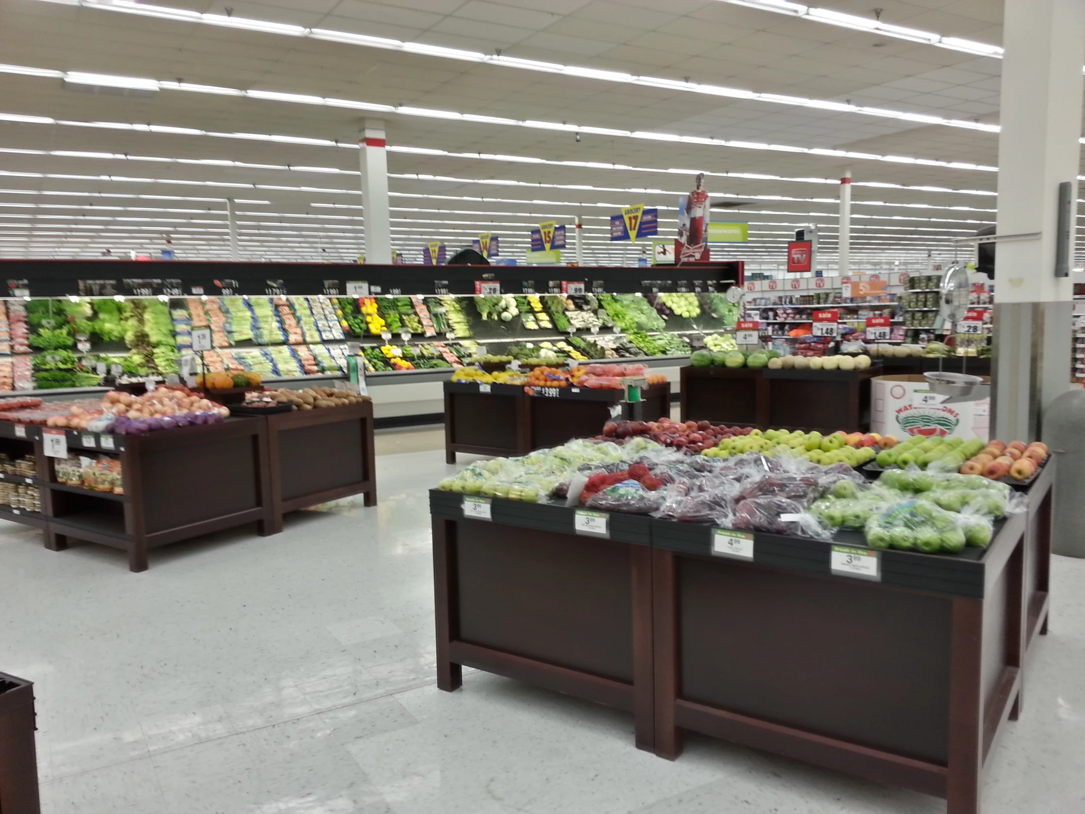 a produce section in a grocery store with vegetables