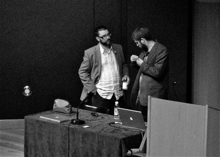 a black and white po of two people in a conference room