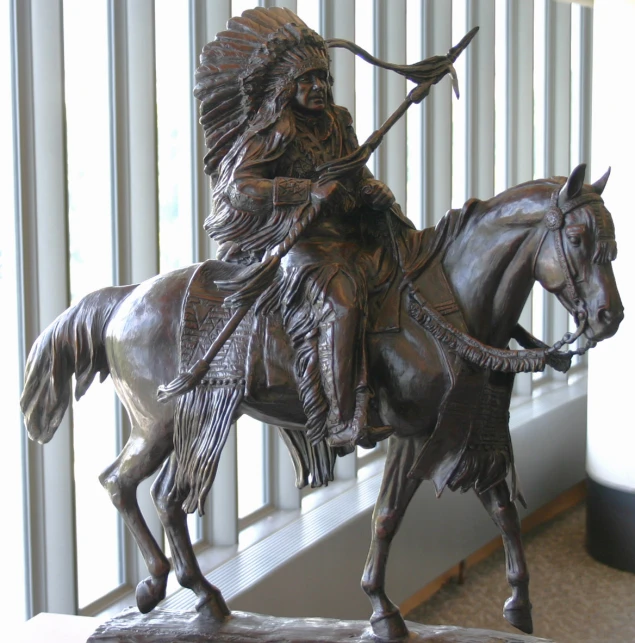 a statue of a native american sitting on top of a horse