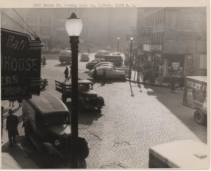 an old black and white po of several cars parked on the side of a street