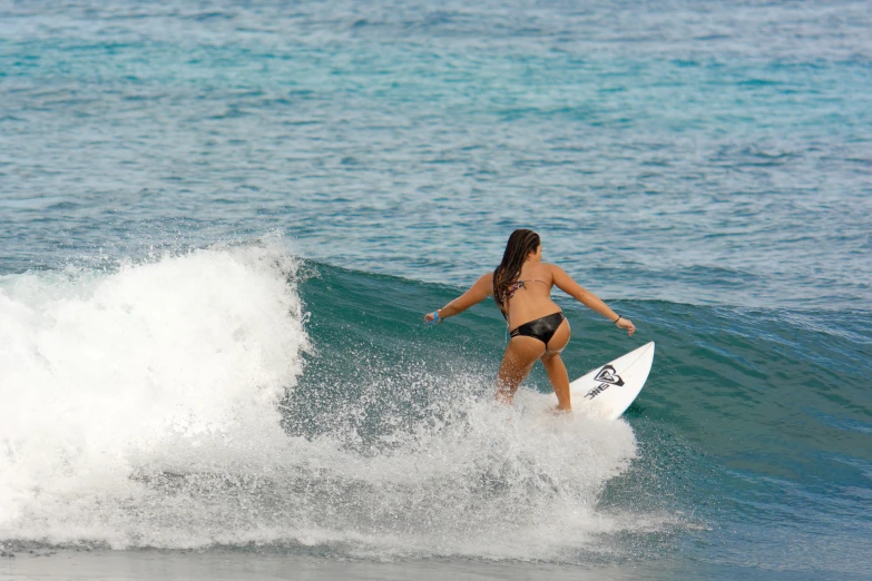 a young woman rides a wave on a surfboard