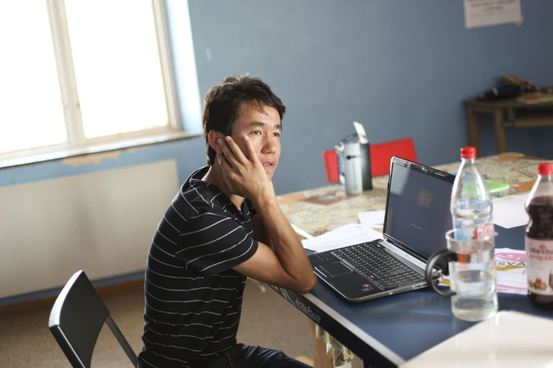 a man sitting at a table with his laptop