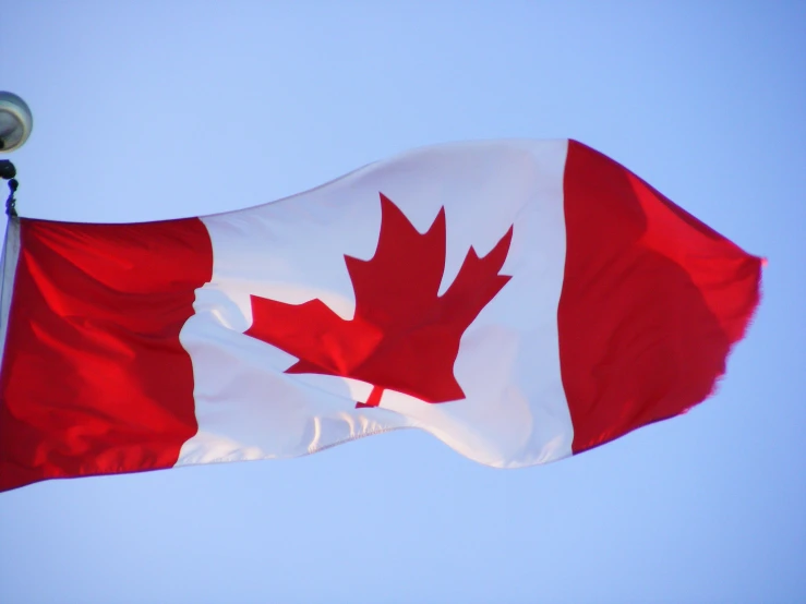 the canadian flag is waving in the wind