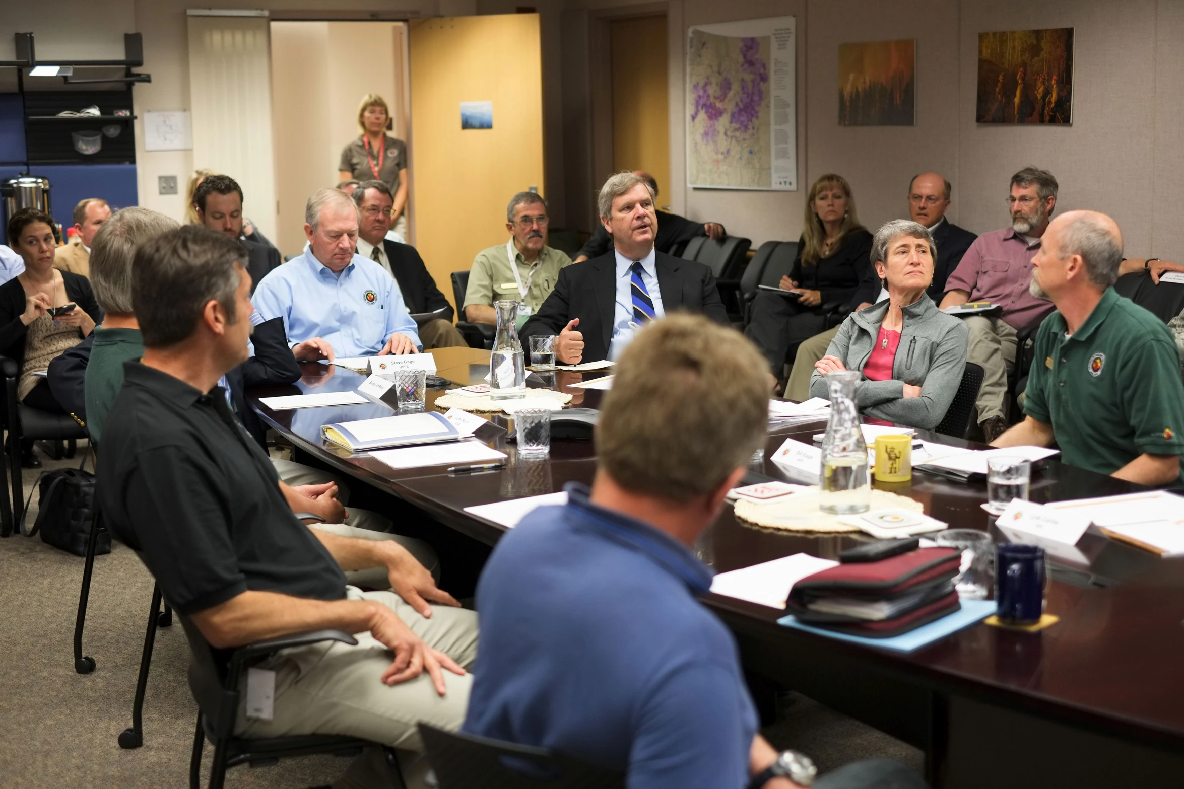 a room full of people sitting at tables during a meeting