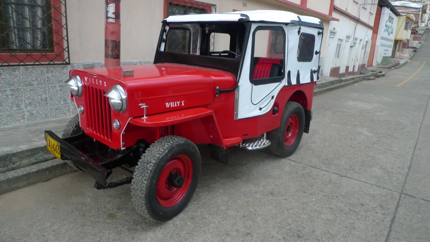 an old model jeep with a white and red cab