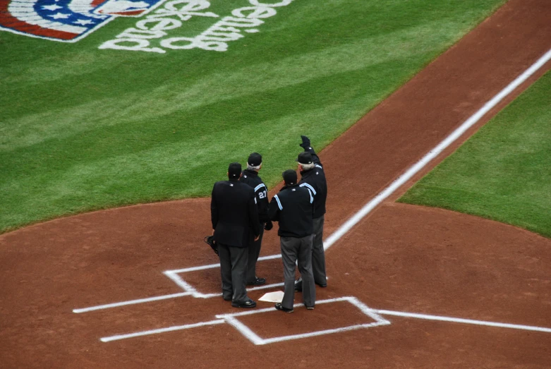 men in suits stand on a baseball diamond giving a salute