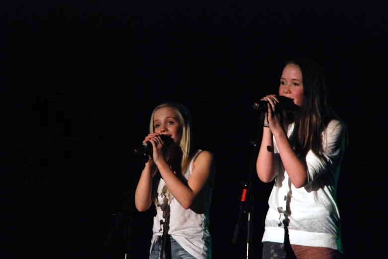 two girls sing and sing on stage
