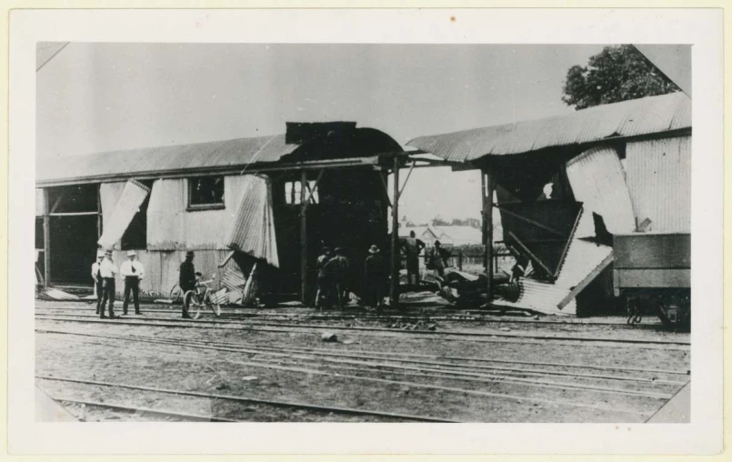 an old po showing a train depot where passengers are standing