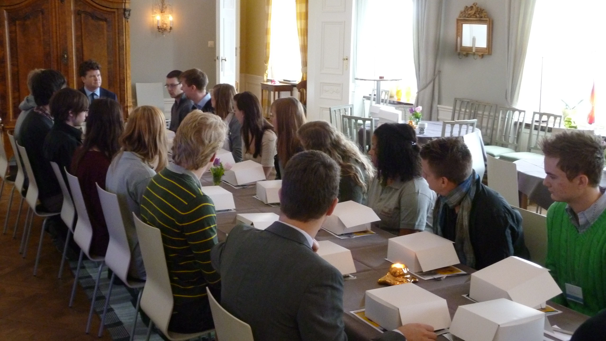 a room full of people sitting at a dining table