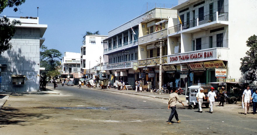 many people walk on the street while many stores sit on the building