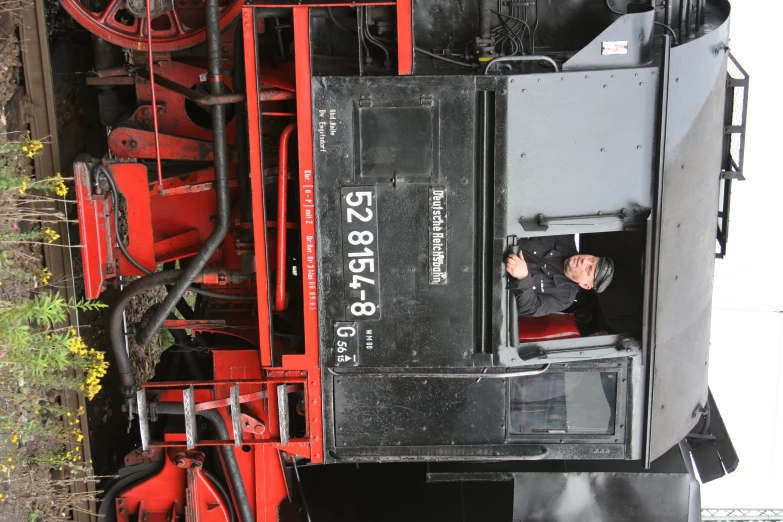 an old black and red train on the tracks