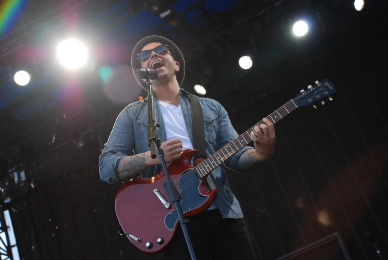 a male singer singing into a microphone and playing guitar