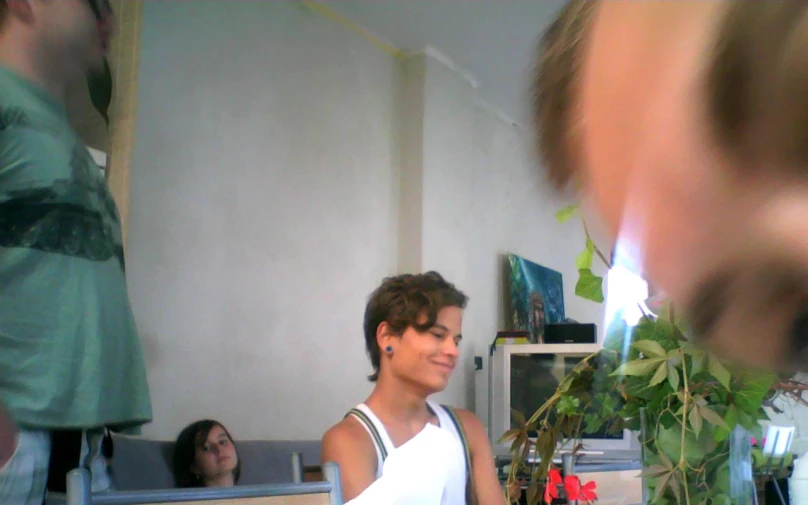 woman in white shirt with plant and people in background