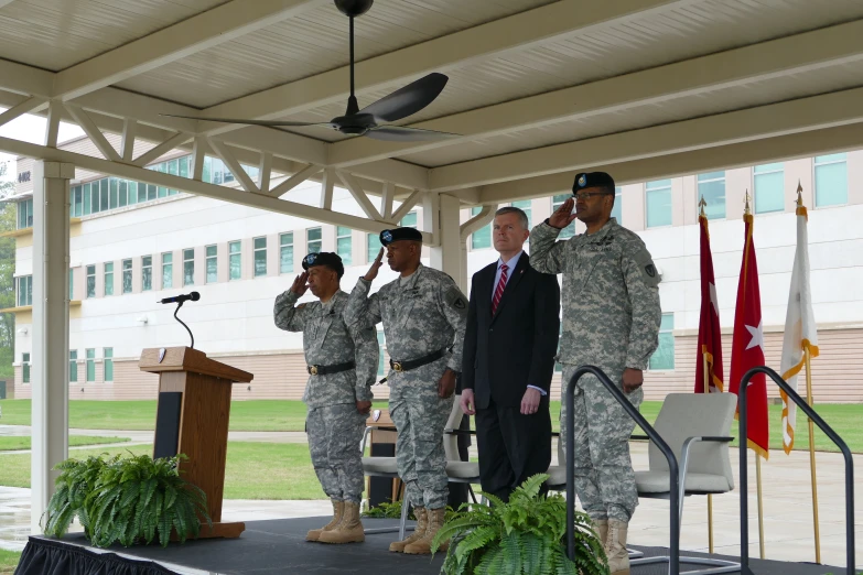 military personnel are gathered around the podiums while the speaker is giving a speech