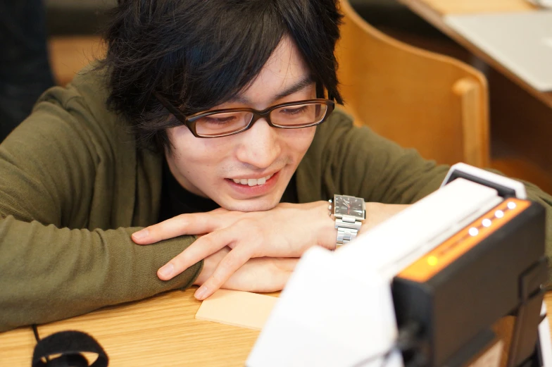 a young person with glasses looking at soing in a case