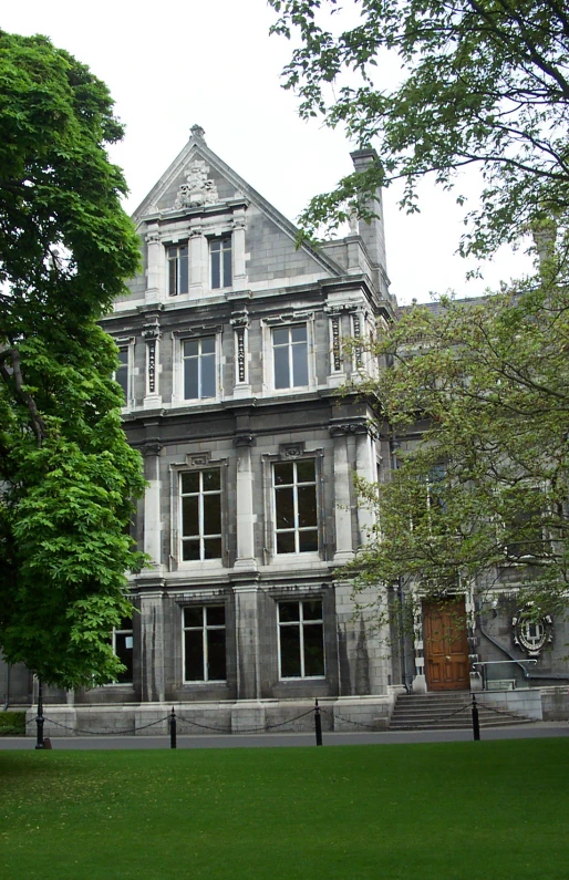 large gray building with windows and a clock in the center