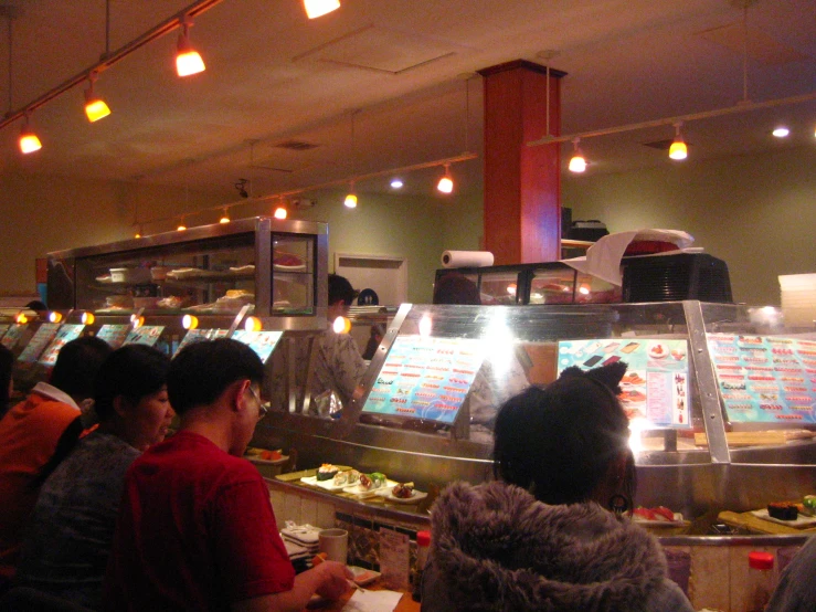 a buffet with food on top of it as people are sitting around