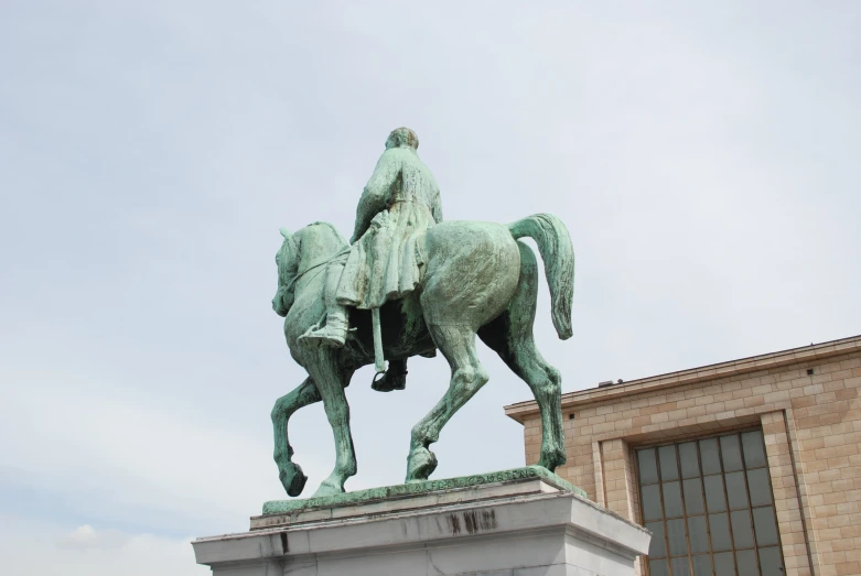 the statue depicts a man with his hand on his back, holding the reins of a horse
