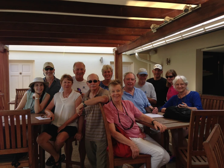 a group of people sitting and standing around each other at a table