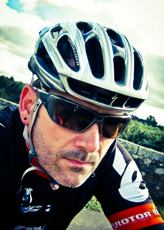 a man wearing a bicycle helmet looking up into the distance