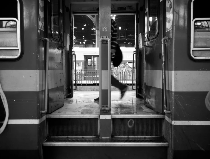 a man that is walking through a door of a train