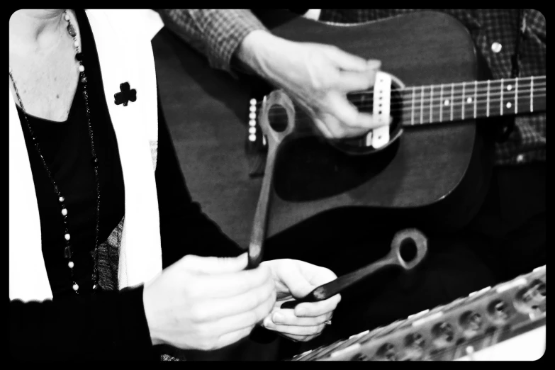 a person is playing guitar while holding a stick