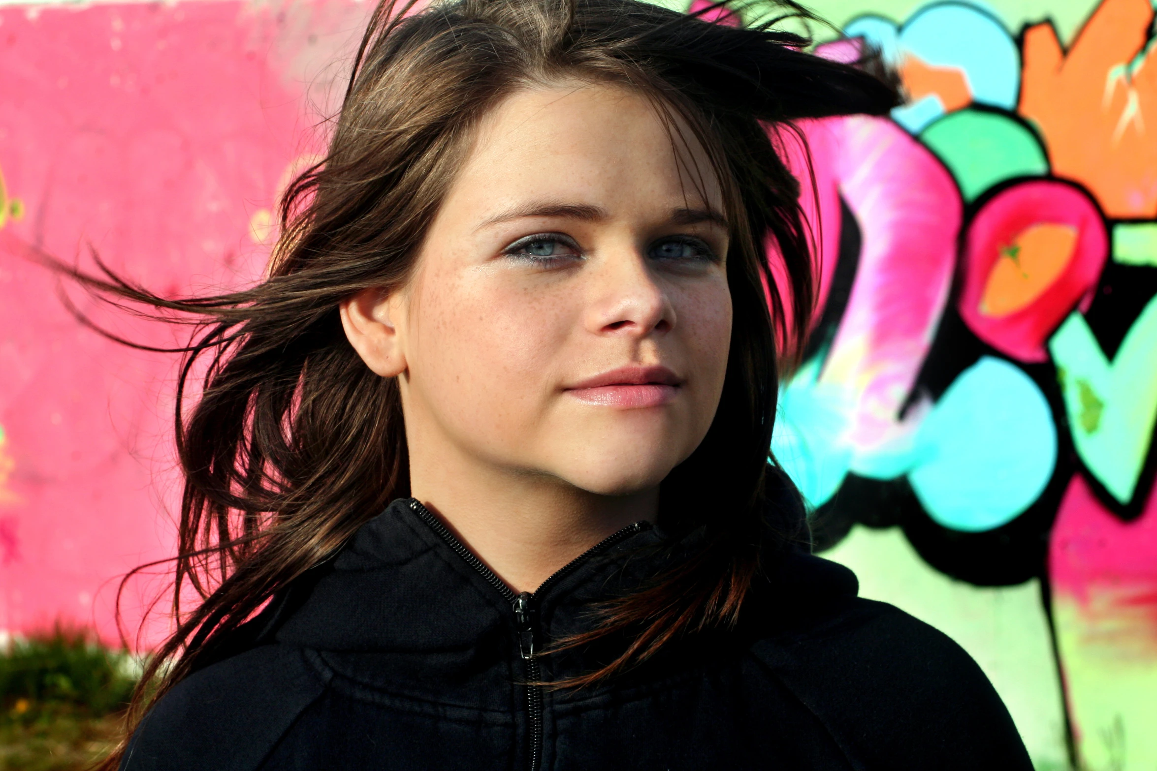 a woman with dark hair looks away from the camera