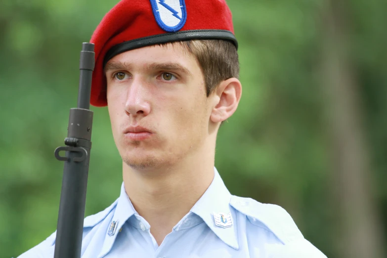 man with a red beret, holds the same gun as his girlfriend