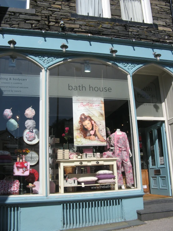 a small fashion store front with shop windows and mannequins outside