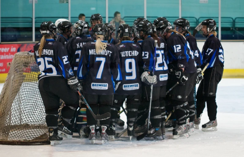 a group of people playing a game of ice hockey