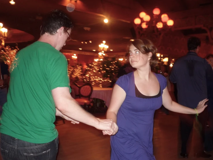 a young man and woman holding hands while dancing
