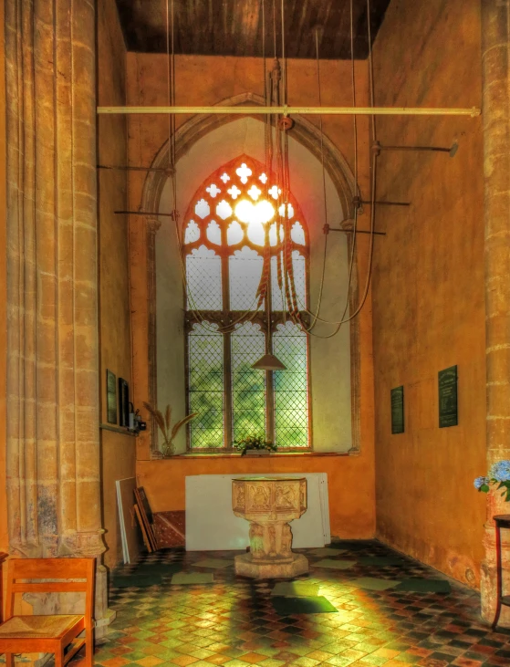 an old church with a stained glass window, a small fountain, a clock, and two chairs