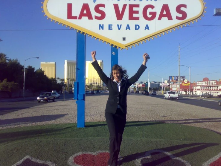a woman poses in front of the las vegas sign