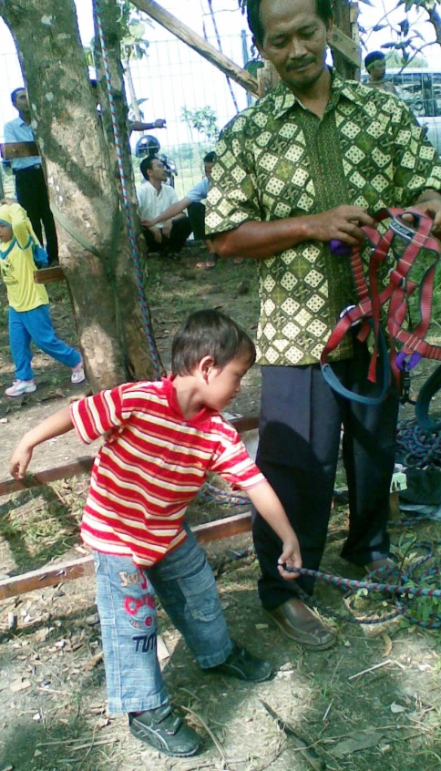 the boy is trying to tie the clothes he wants to wear