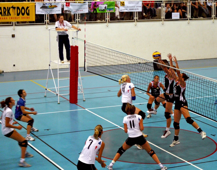 a volley ball game being played in a gym