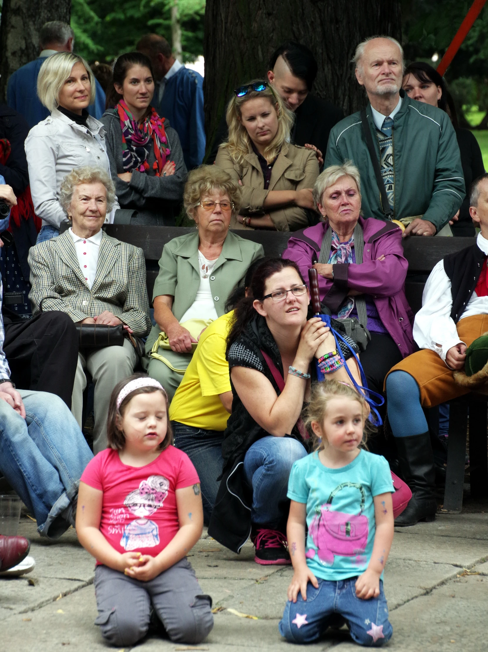 an old man is talking to many women and girls