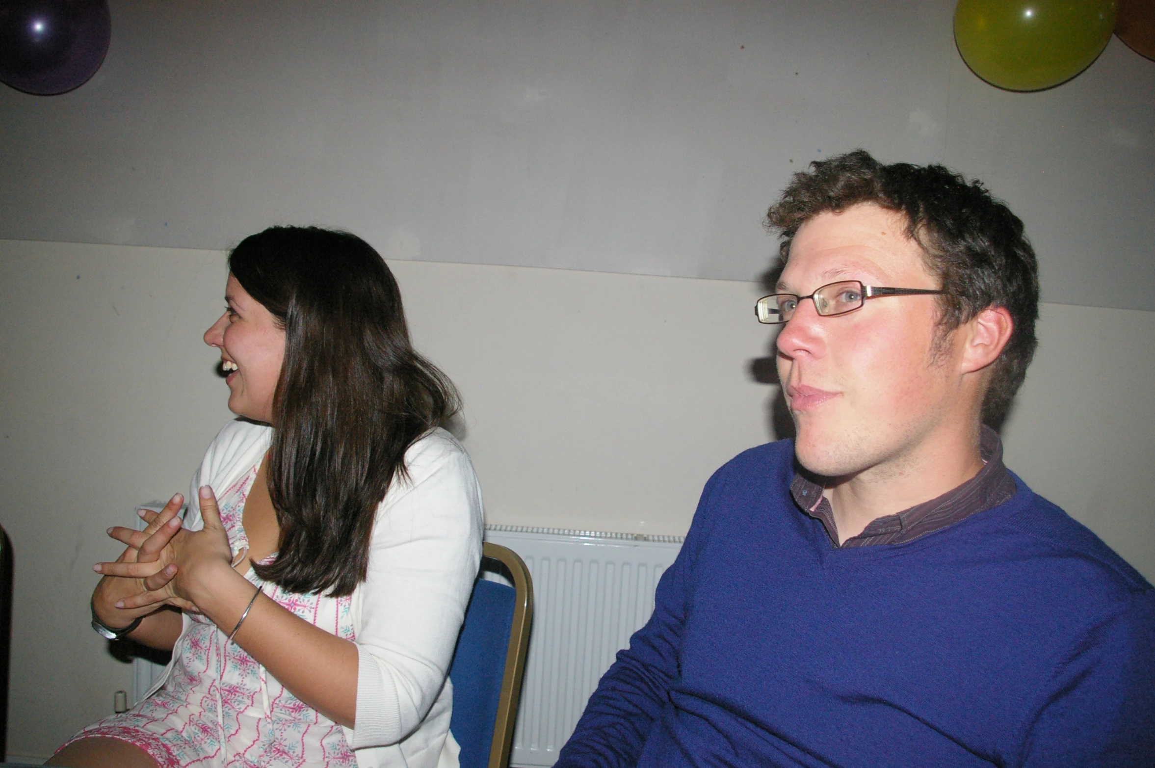 a man and a woman sitting at a table looking at each other