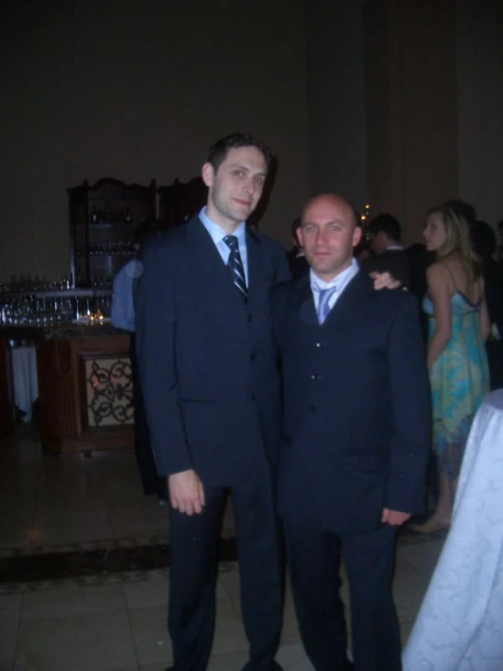 two men in suits standing close to one another