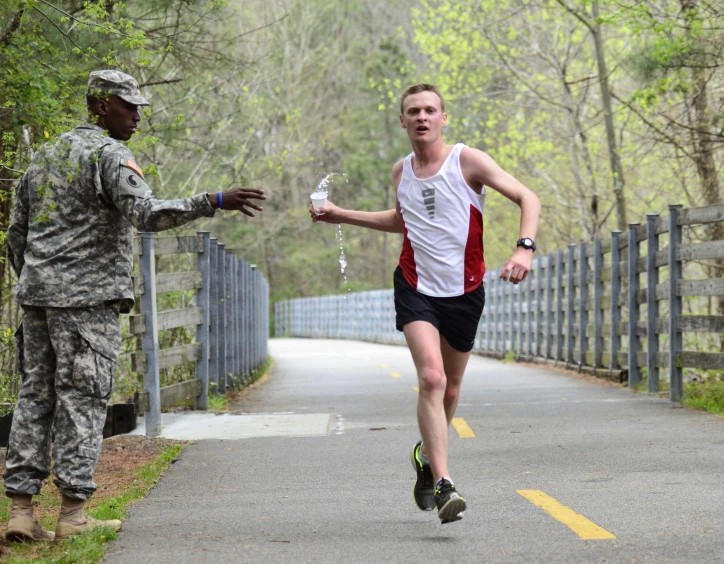 a man in military fatigues is crossing a bridge by an army officer