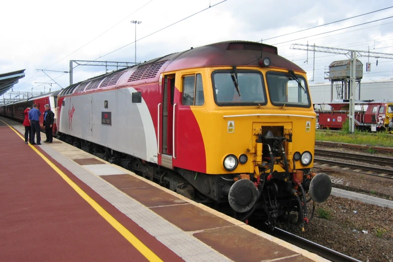 a passenger train on a track with people next to it