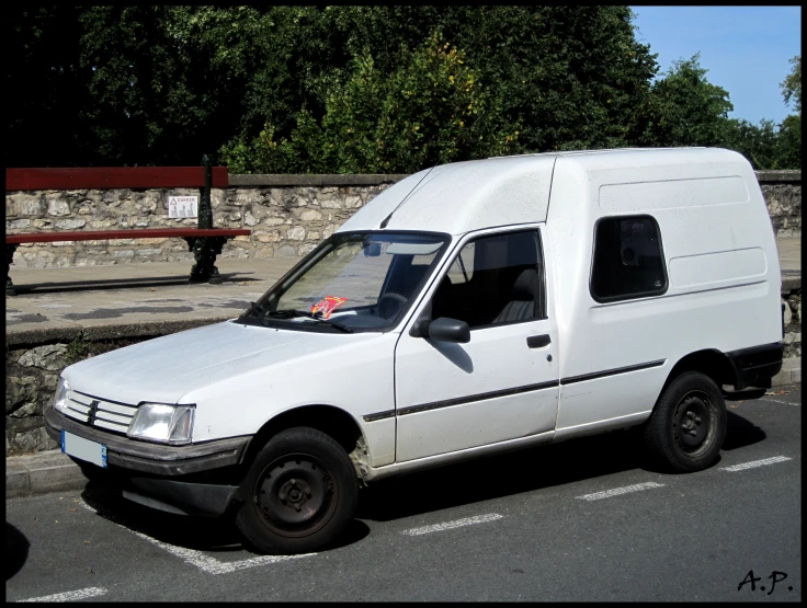 a small white van parked in the street