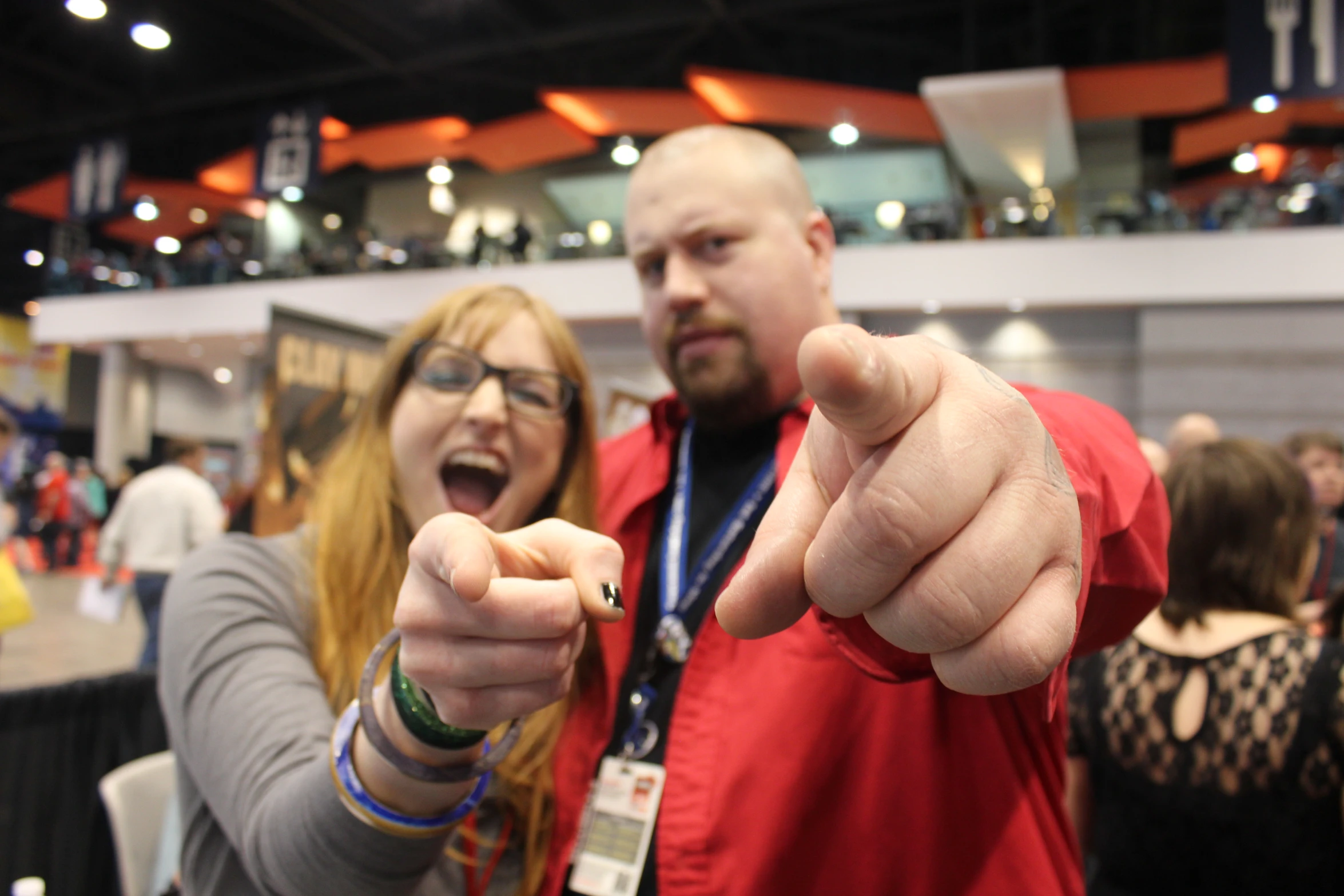 two people pointing at the camera with their thumbs up