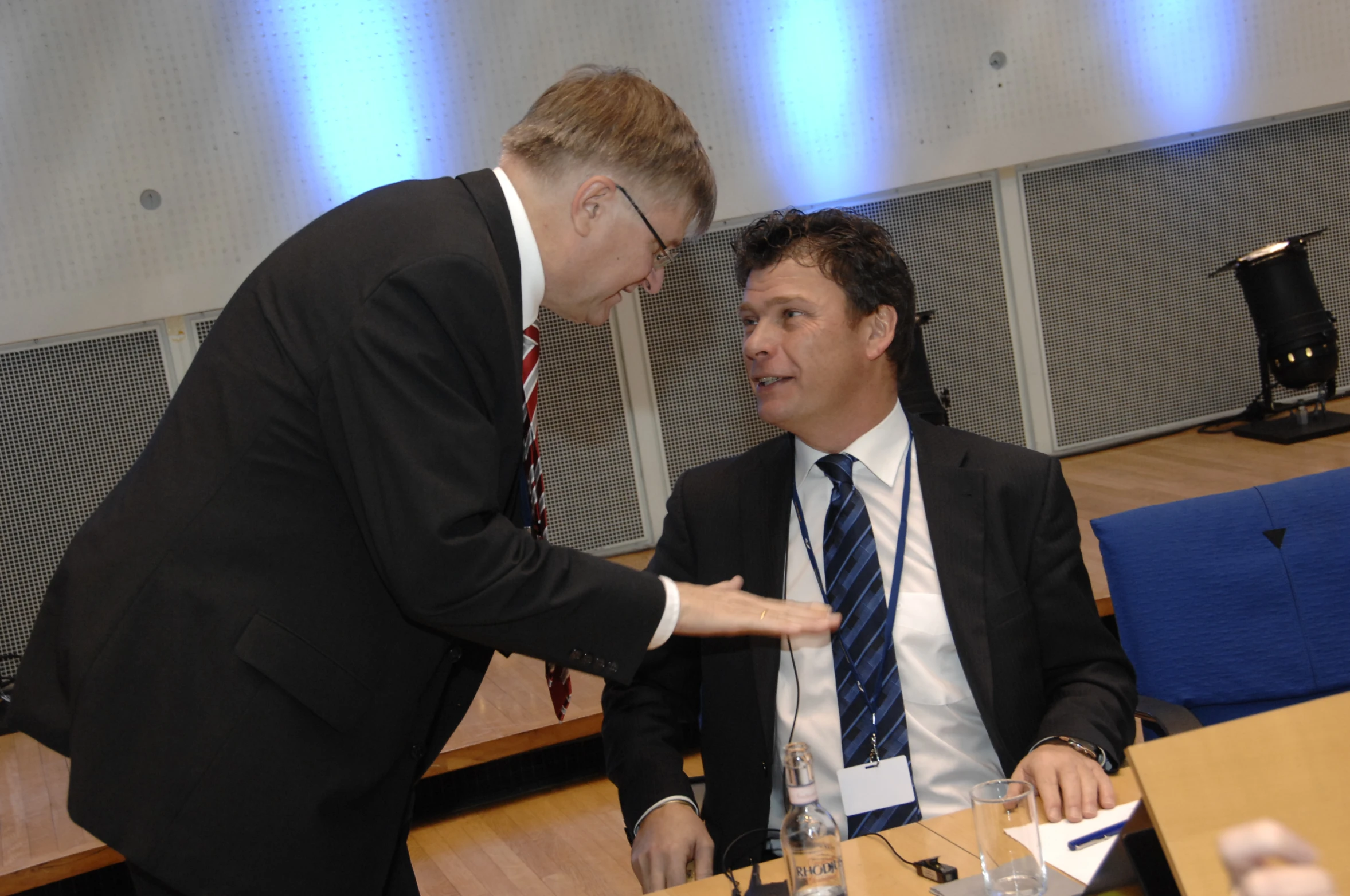 two men are sitting at a table discussing soing