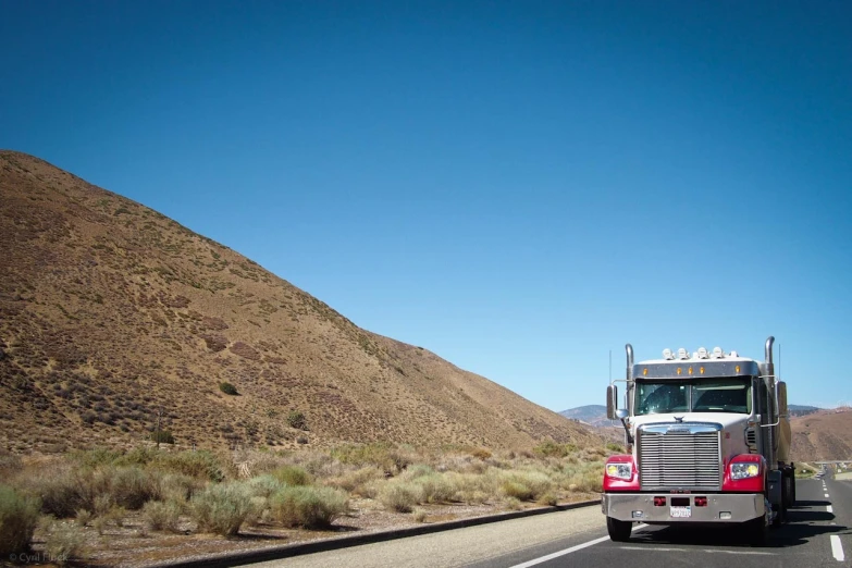 truck on the side of road near mountains and sky