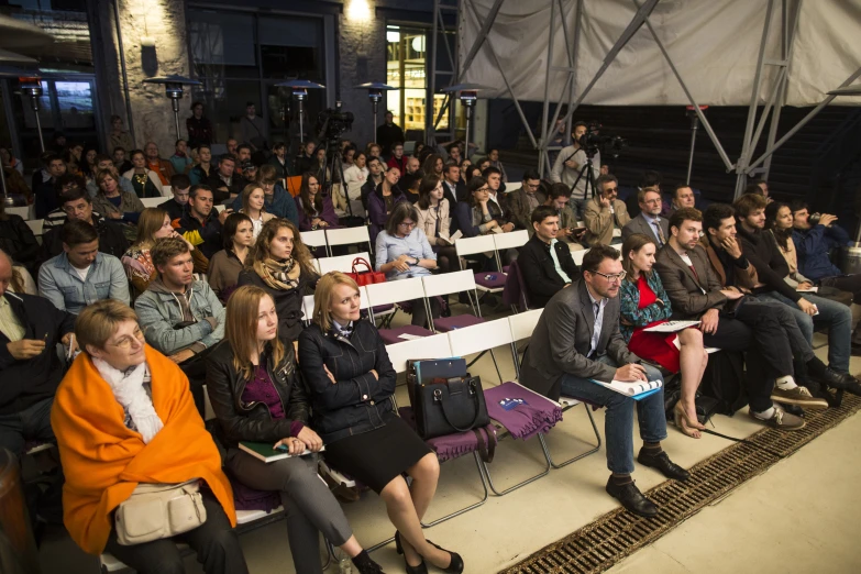 people at a meeting with several seated in chairs