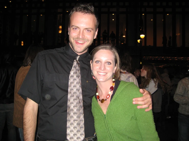 a woman and man are posing for the camera