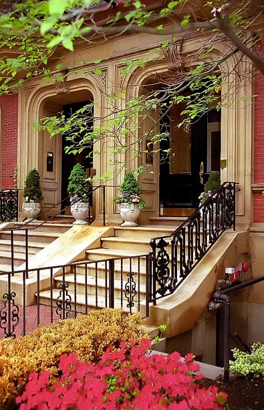 a beautiful entrance to a brick building with wrought iron railing and steps