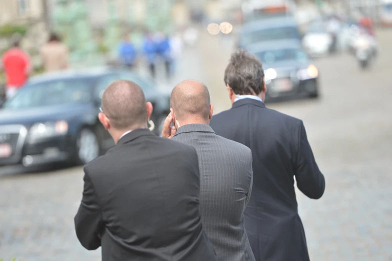 two men dressed up and walking together outside